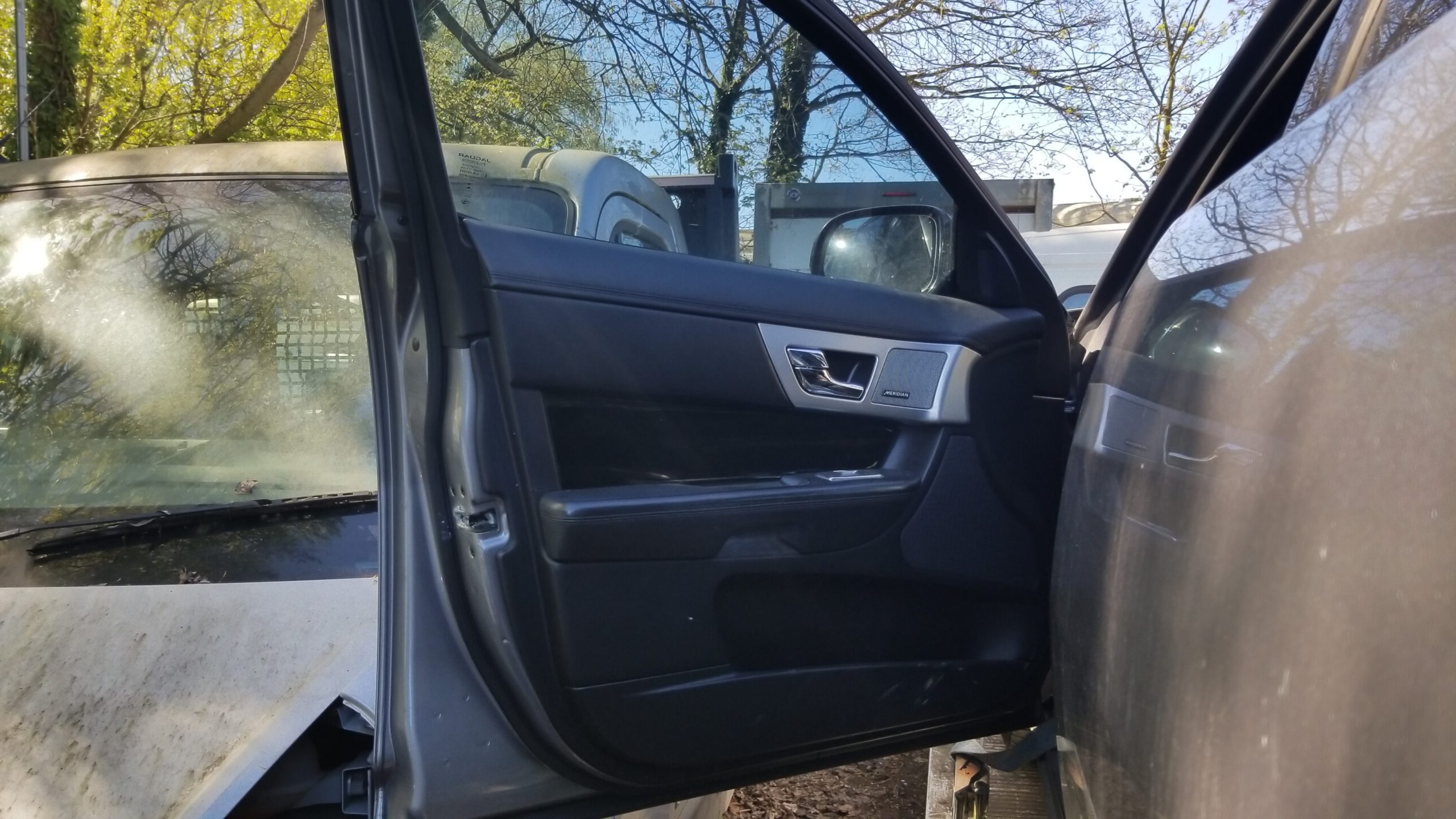 Interior side of Jaguar XF 2013 front left door showing panel and fittings