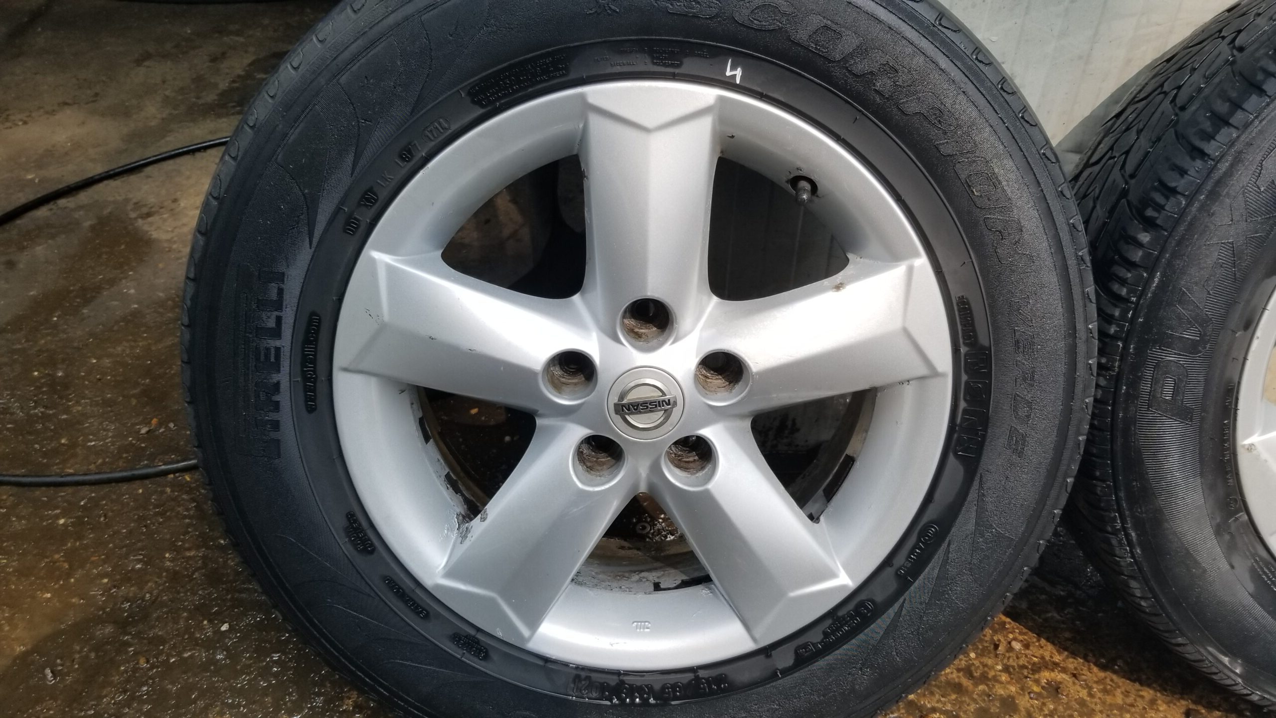 Close-up of wheel face showing Nissan badge and finish